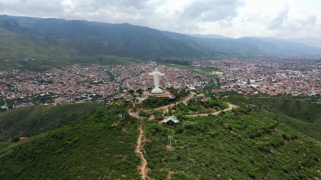 High angle drone shot circling the colossal Cristo de la Concordia religious landmark in Bolivia.