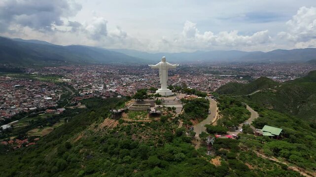 Breathtaking drone view of the giant Jesus Christ statue with the city of Cochabamba in the background.