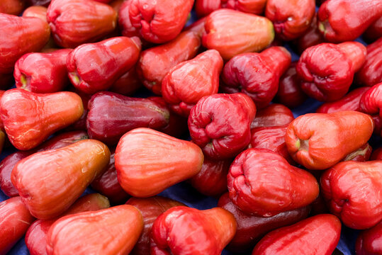 Fresh ripe red wax apples displayed for sale at an Asian fruit market stall