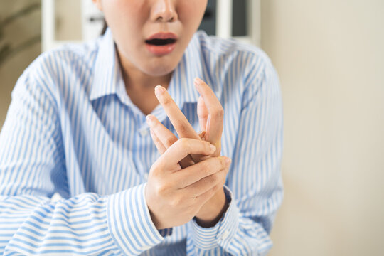 Health care and medical concept, rheumatism asian woman hand pain from cramp, trigger finger, wrist pain touching massaging, hand holding ache joint, arthritis inflammation.Chronic disease from injury