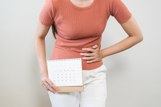 Menstruation, periods cycle day of monthly, hurt asian young woman, female hand holding, marking symbol on calendar for missed and delay or late. Medical, healthcare, gynecological concept. Copy space