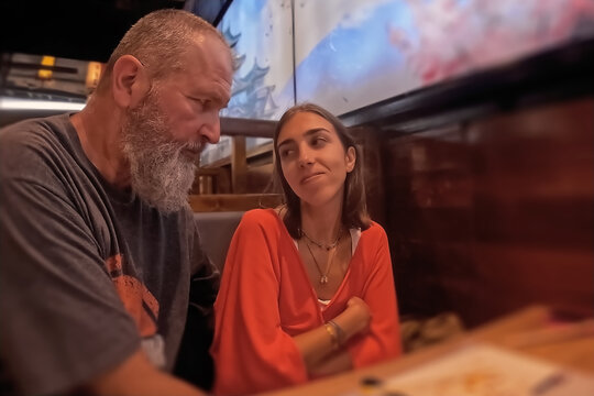 Mature man and young woman in cafe