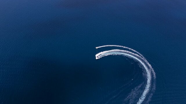 Speedboat tracing a sweeping curved wake