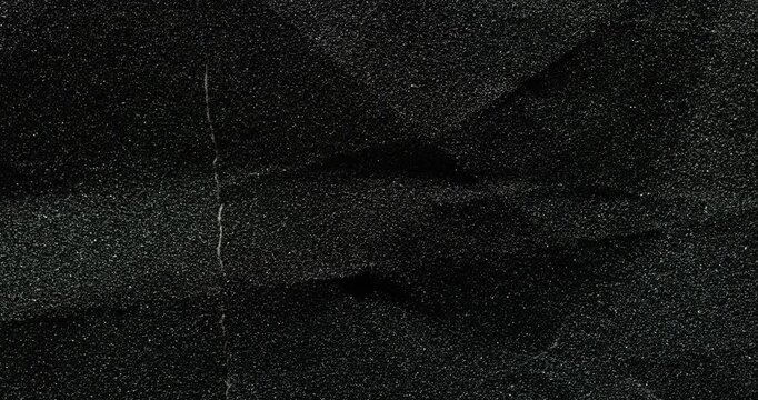 Black Granular Texture. Close-up rough granular surface with deep cracks, slow subtle camera movement. Ideal for industrial, urban and natural backgrounds.	