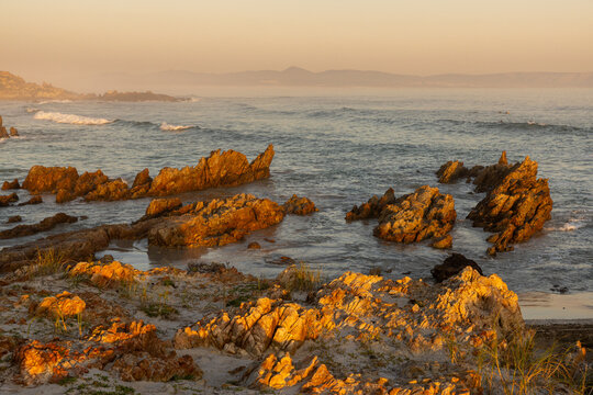 beautiful rugged rocky coastline of Kammabaai Beach, Hermanus, South Africa at sunset and dusk