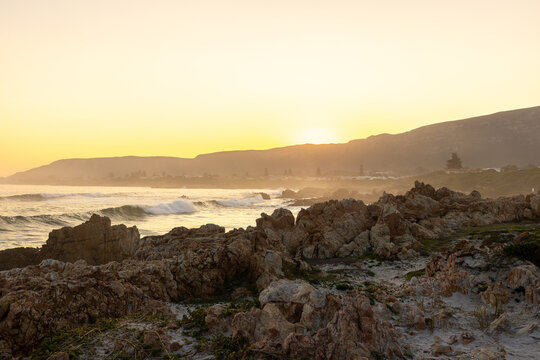 beautiful rugged rocky coastline of Kammabaai Beach, Hermanus, South Africa at sunset and dusk