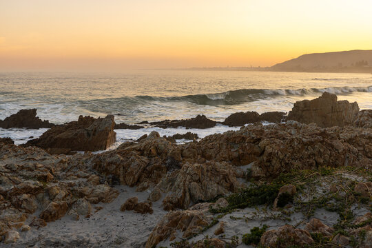 beautiful rugged rocky coastline of Kammabaai Beach, Hermanus, South Africa at sunset and dusk