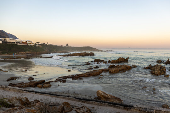 beautiful rugged rocky coastline of Kammabaai Beach, Hermanus, South Africa at sunset and dusk