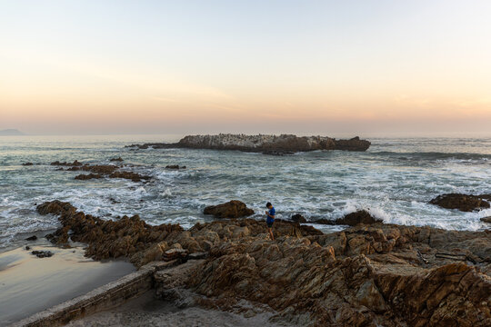 beautiful rugged rocky coastline of Kammabaai Beach, Hermanus, South Africa at sunset and dusk