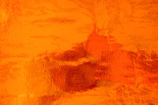 Copper gold foil leaf metallic gradient texture background with uneven surface. Abstract shiny amber orange brass metal texture wallpaper