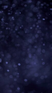 Blue Floating Particles on Dark Background. Soft glowing particles drift through darkness, creating an atmospheric abstract bokeh effect.	