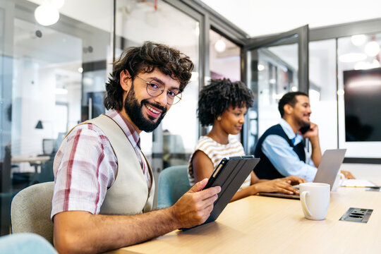 Diverse team collaborating in a contemporary office, focusing on business growth and innovation with digital devices