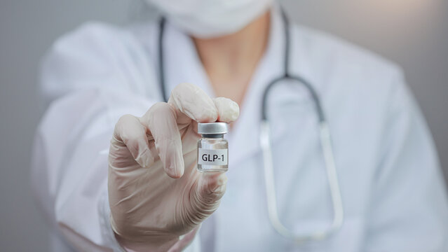 Confident doctor holding hormone vial offers professional hope for weight management treatment to patient seeking healthy lifestyle change