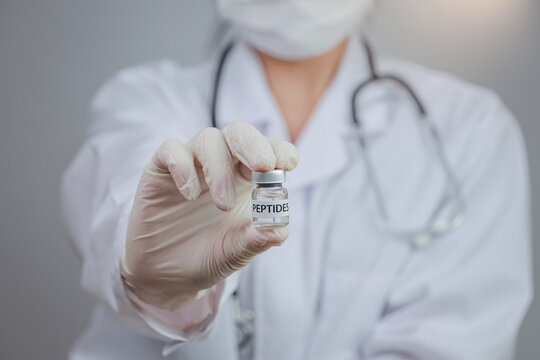 Confident female doctor holding peptide vial inside wellness clinic showcases professional medical healthcare treatment with caring hand glove