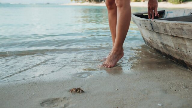 Bare feet walking along tropical shoreline with crab with walking wet sand summer vacation tropical island