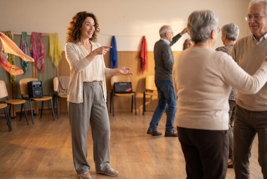 Dance instructor leading active senior adults in a joyful ballroom dancing class