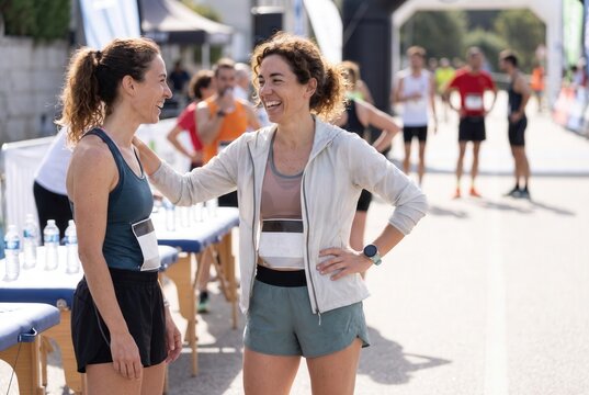 Two women celebrating and laughing after finishing a running race or marathon
