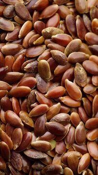 Brown Flax Seeds Texture. Macro view of brown linseeds filling the frame with natural detail and gentle movement. Ideal for healthy food backgrounds.