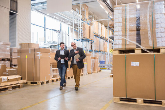 Two men walking in factory warehouse