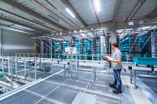 Man with documents in automatized high rack warehouse