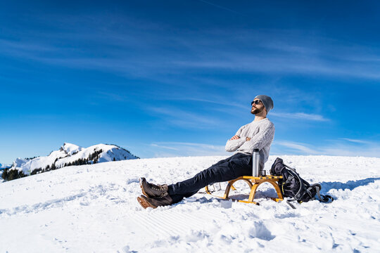 Germany, Bavaria, Brauneck, man in winter in the mountains having a break
