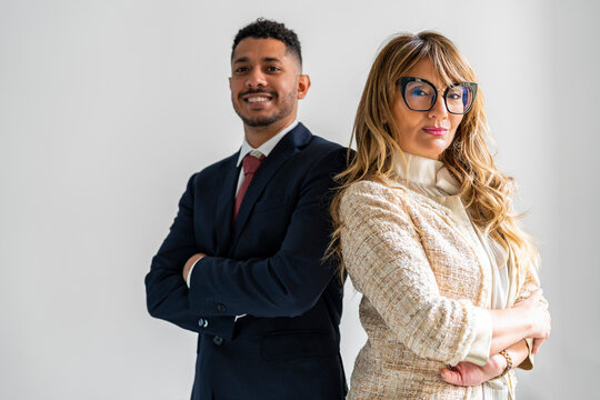 Confident business partners standing with arms crossed against white background
