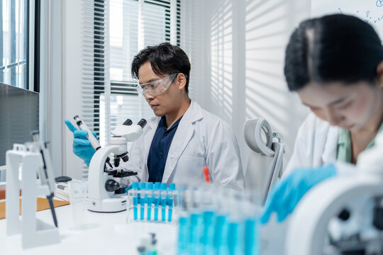 Scientists perform laboratory research using microscopes, test tubes, and modern scientific equipment to analyze samples, representing biotechnology, healthcare, diagnostics, and medical innovation.