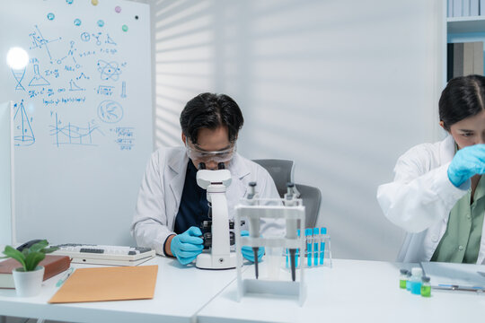 Scientists perform laboratory research using microscopes, test tubes, and modern scientific equipment to analyze samples, representing biotechnology, healthcare, diagnostics, and medical innovation.
