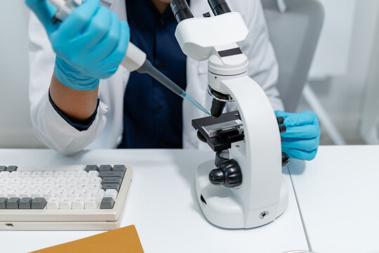 Scientists perform laboratory experiments using microscopes, pipettes and test tubes while analyzing samples in modern research laboratory, representing biotechnology, diagnostics and medical science.