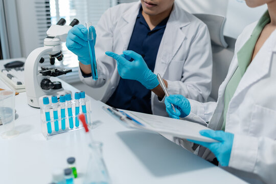 Scientists perform laboratory experiments using microscopes, pipettes and test tubes while analyzing samples in modern research laboratory, representing biotechnology, diagnostics and medical science.