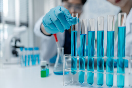 Scientists perform laboratory experiments using microscopes, pipettes and test tubes while analyzing samples in modern research laboratory, representing biotechnology, diagnostics and medical science.