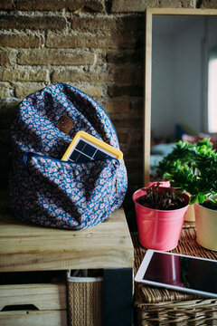 Solar panel charger in a backpack at home and a tablet