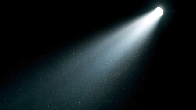 A bright spotlight beam illuminates fine dust particles suspended in dark space  creating a dramatic and clean visual effect