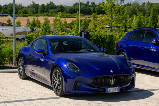 Arlon, Belgium - June 22nd 2026 : View on a blue Maserati GranTurismo Folgore parked on a parking lot with vegetation in the background.