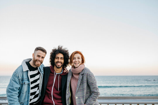 Portrait of three happy friends at the sea