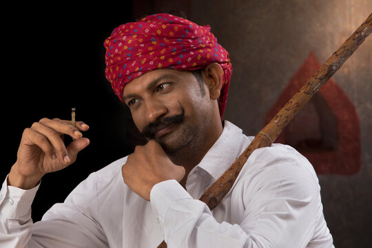 Farmer wearing turban and smoking cigar 