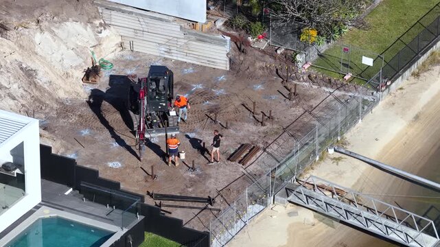 Aerial View of Excavator Drilling Foundations at Waterfront Construction Site