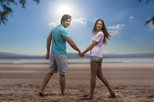 Happy couple hand in hand on the beach