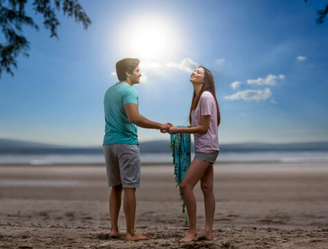 Happy couple hand in hand on the beach