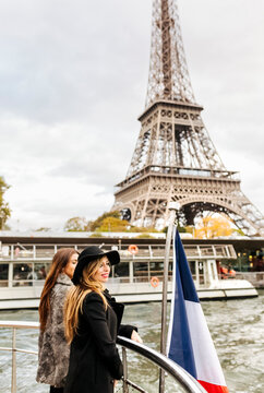 Paris, France, two tourists taking a cruise on Seine River with Eiffel Tower in the background