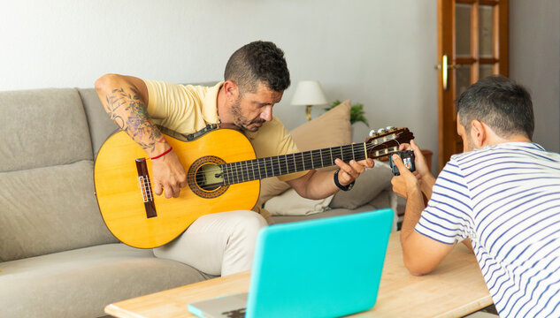 Musician recording guitar music for online content creation