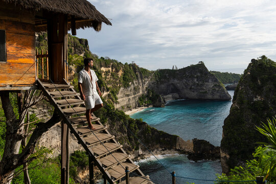 Man admires the ocean view from a treehouse in Nusa Penida
