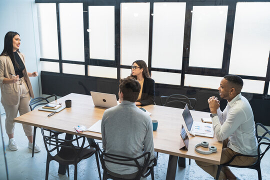 Businesswoman discussing strategy with male and female colleagues in coworking office