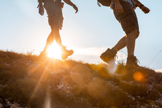 Italy, Monte Nerone, close-up of two men hiking in mountains at sunset