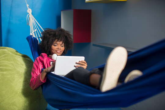 Employee with tablet relaxing in hammock