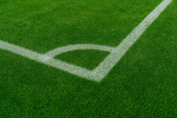 Fototapeta premium Freshly maintained green soccer field with bright white corner lines close up sports ground view
