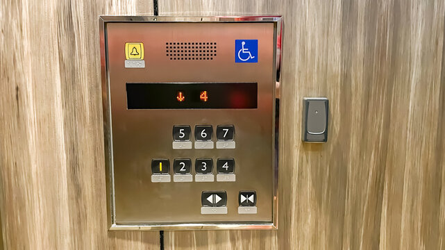 Stainless steel elevator control panel with floor buttons, Braille, digital display and RFID reader for secure access in a modern residential condominium.
