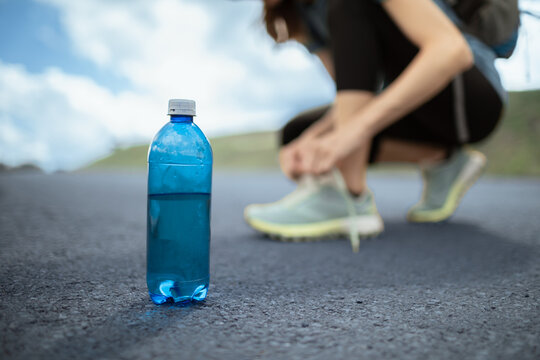 Drinking Water Bottle On Road Before Outdoor Run Emphasizing Hydration And Staying Hydrated During Summer Heat
