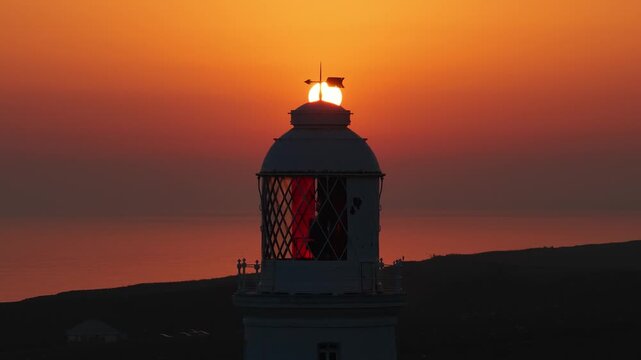 Cinematic drone footage flying over Nash Point Lighthouse at sunset, revealing dramatic cliffs, golden skies and the scenic South Wales coastline.