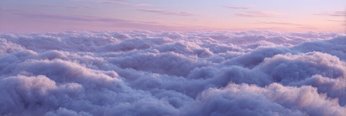 Obraz premium Panoramic aerial view of soft, fluffy clouds bathed in serene pastel pink and purple sunset light, creating a dreamy, ethereal cloudscape.